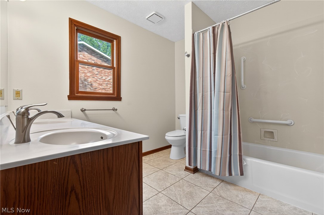 5346 Burlawn Street Northwest Canton, OH 44708 - Photo 17 of 40 Bathroom featuring a wood-finish vanity with a white countertop, an undermount sink, and a brushed nickel faucet