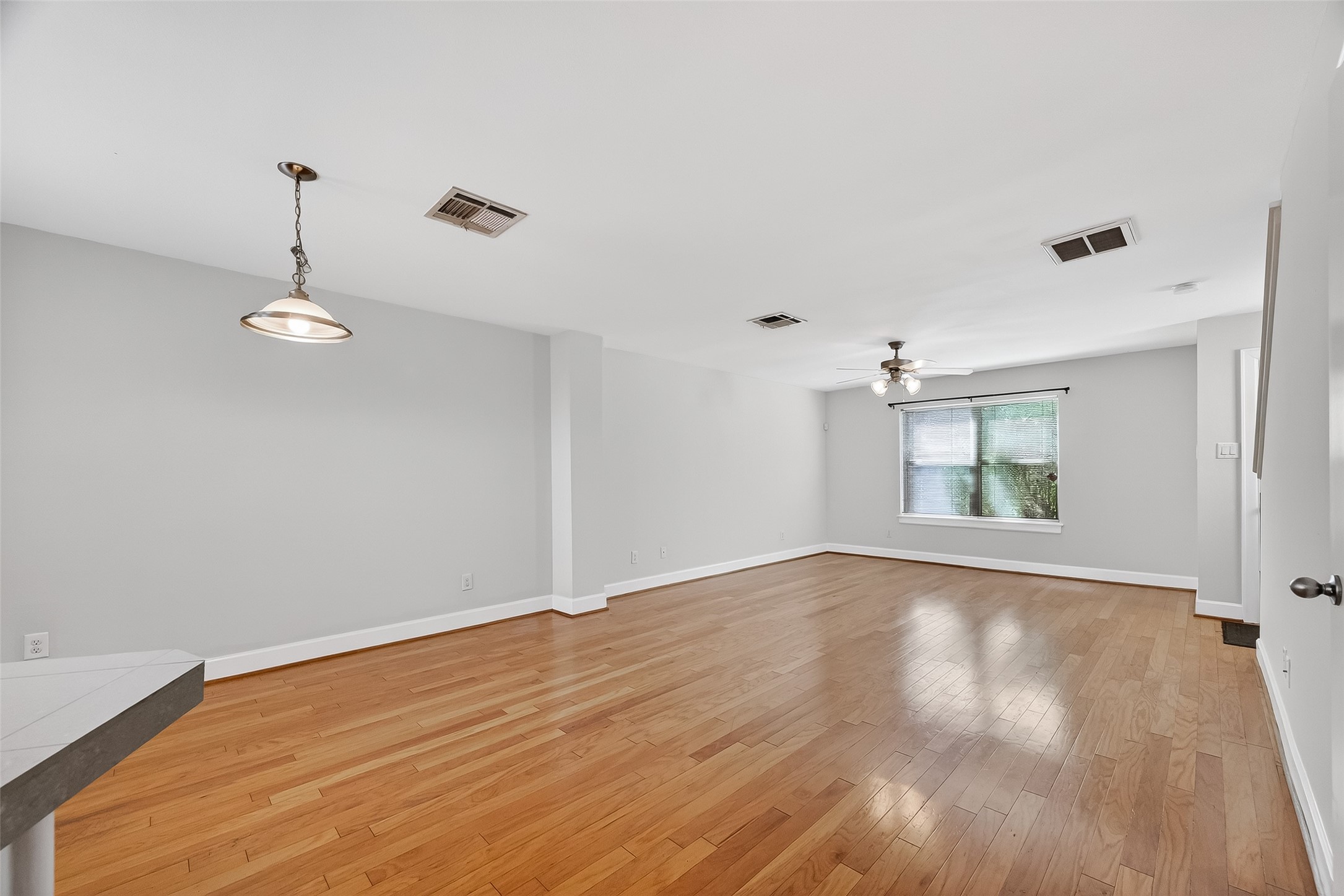5951 S Loop East, Unit 47 Houston, TX 77033 - Photo 11 of 37 This spacious, open-concept living area features beautiful hardwood floors, neutral-colored walls, and ample natural light from a large window creating a comfortable and inviting atmosphere.