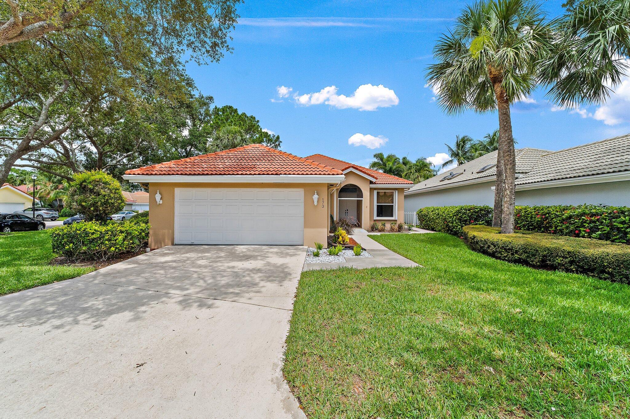 173 East Hampton Way Jupiter, FL 33458 - Photo 2 of 28 a front view of a house with a garden and yard