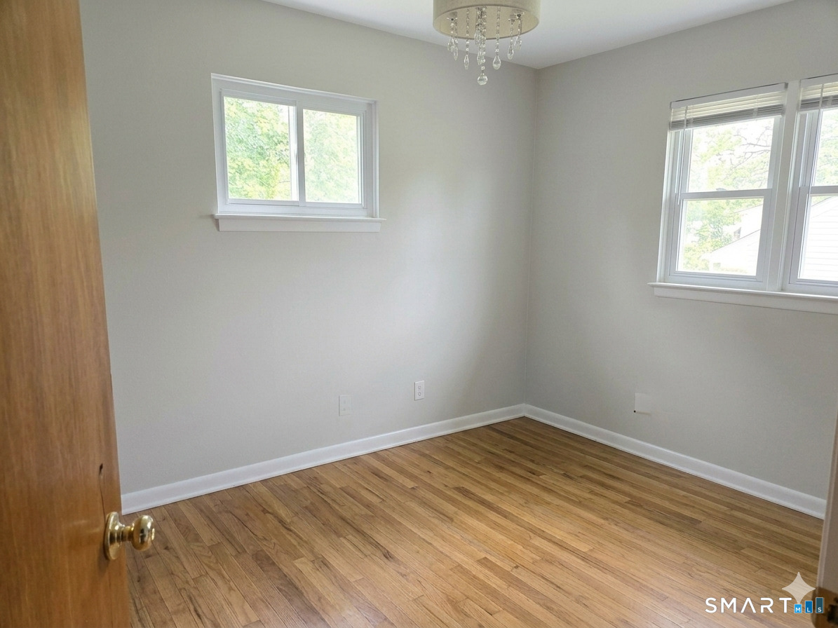 23 Ridgecrest Road Wallingford, CT 06492 - Photo 6 of 7 an empty room with wooden floor and windows