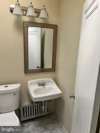 a bathroom with a toilet a sink and mirror