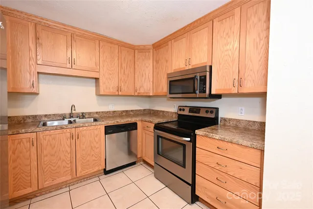 a kitchen with granite countertop cabinets stainless steel appliances and a sink