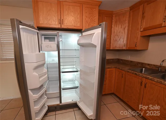 a kitchen with granite countertop a refrigerator and a sink