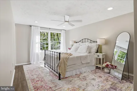 an empty room with wooden floor chandelier and windows