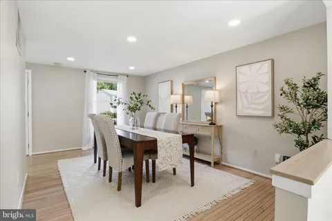 a kitchen with stainless steel appliances a stove a sink a microwave a refrigerator white cabinets and wooden floor