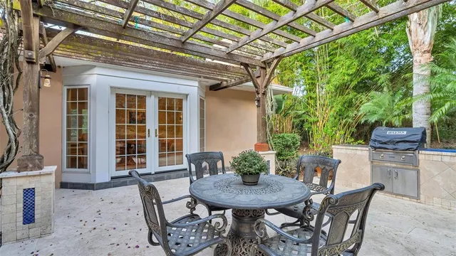 a view of a house with potted plants and a large tree