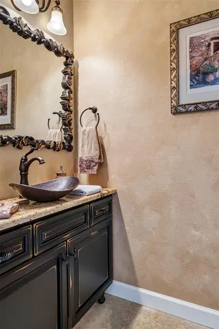 a bathroom with a granite countertop sink a mirror and shower