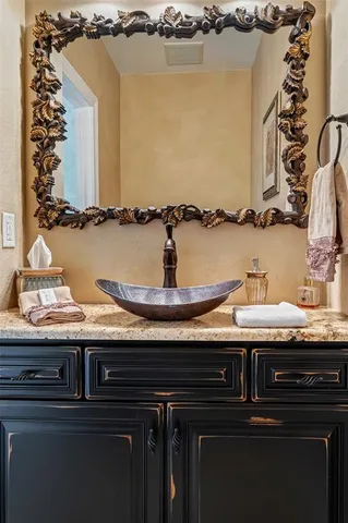 a bathroom with a granite countertop double vanity sink and a mirror