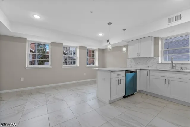 a kitchen with granite countertop a stove sink and cabinets