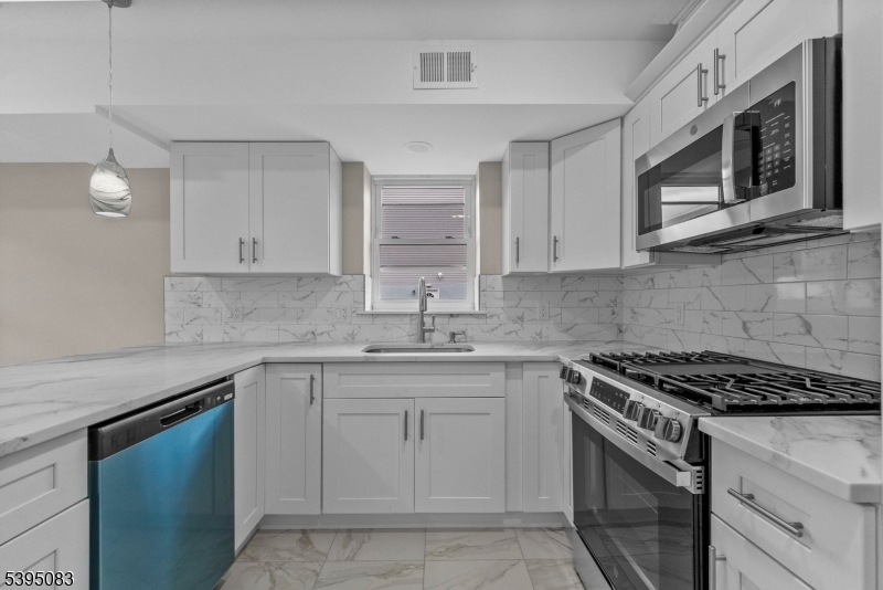 24 Garibaldi Avenue Newark, NJ 07114 - Photo 6 of 13 a kitchen with cabinets appliances a sink and a counter top space