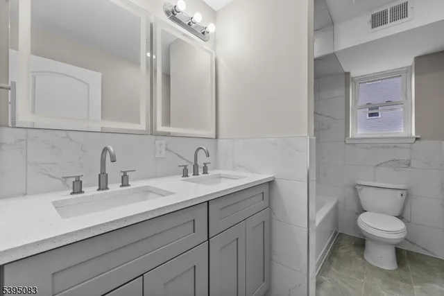 a bathroom with a toilet a sink and mirror