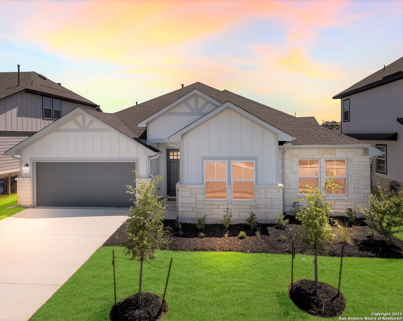 a front view of a house with a garden and yard