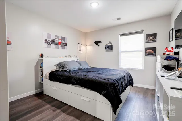 a bedroom with a bed and a wooden floor