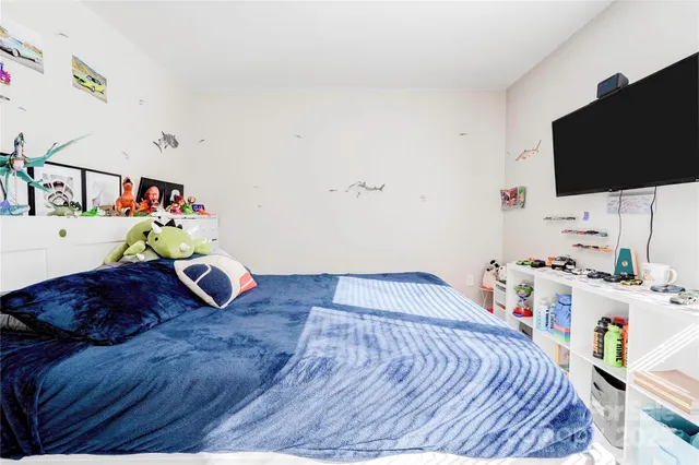 a bedroom with a bed and flat screen tv