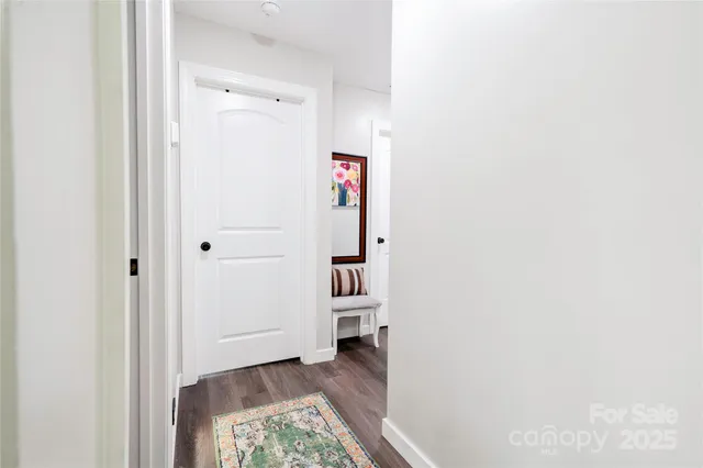 a view of a hallway with wooden floor and closet