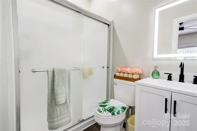 a bathroom with a granite countertop sink a toilet and shower