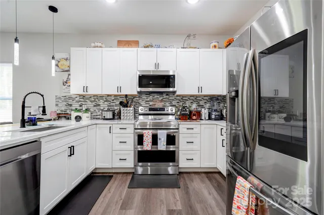 a kitchen with stainless steel appliances a stove sink and refrigerator