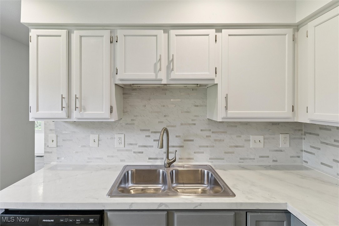 3930 Wood Road Madison, OH 44057 - Photo 22 of 45 Kitchen with tasteful backsplash, white cabinetry, and black dishwasher