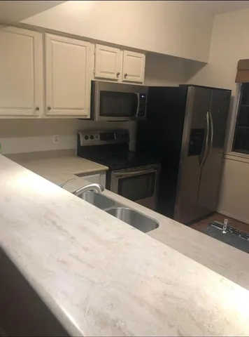 a kitchen with stainless steel appliances a refrigerator and a microwave