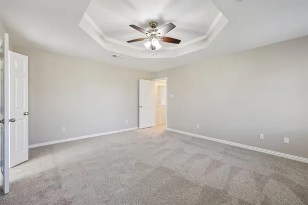 an empty room with closet and a ceiling fan