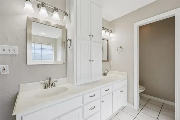 a en suite bathroom with a double vanity sink mirror and toilet