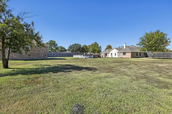 a view of a green field with house in the background