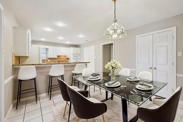 a view of a dining room with furniture a chandelier and wooden floor