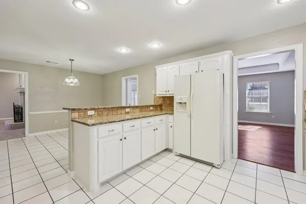 a large kitchen with a sink and a refrigerator