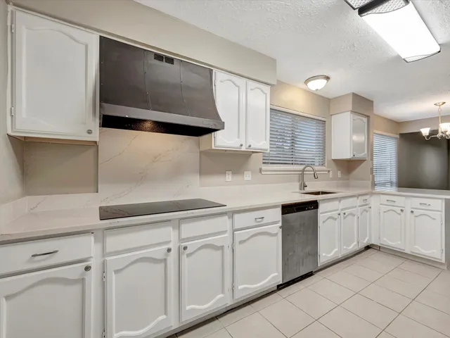 a kitchen with white cabinets a sink and dishwasher