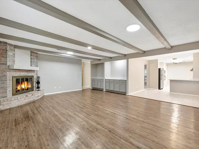 a view of an empty room with a fireplace and a window