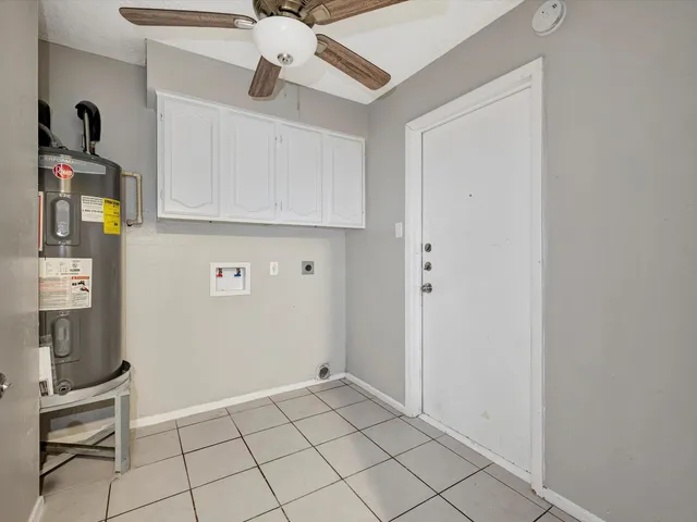 a view of an empty room and chandelier fan