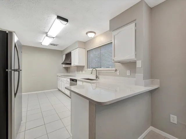 a kitchen with stainless steel appliances a sink and a refrigerator