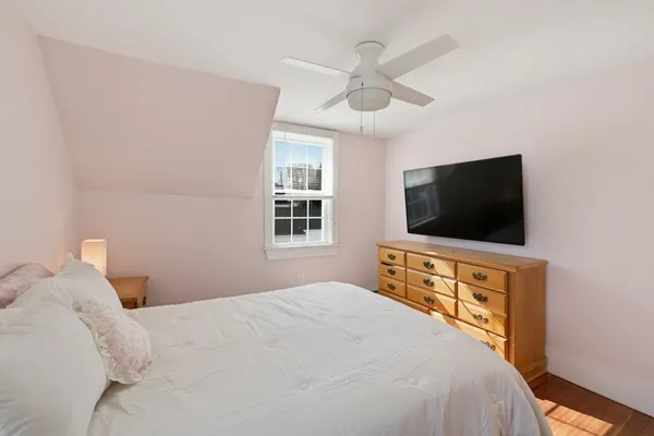 a bedroom with a bed and a flat screen tv on the dresser