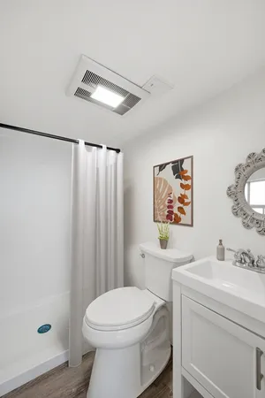 a bathroom with a sink a toilet and shower curtain