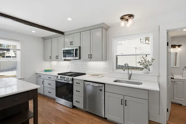 a kitchen with a sink stove cabinets and refrigerator