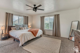 19 East Southfield Road Spanish Fork, UT 84660 - Photo 68 of 74 Bedroom with light carpet, multiple windows, and a ceiling fan