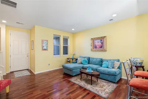 a living room with furniture and a wooden floor