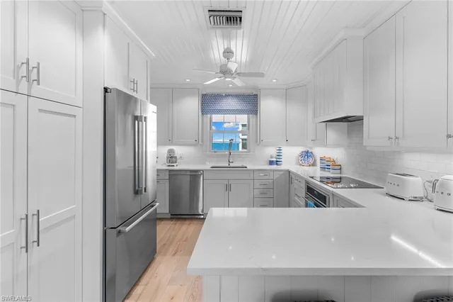 a kitchen with stainless steel appliances a refrigerator sink and cabinets
