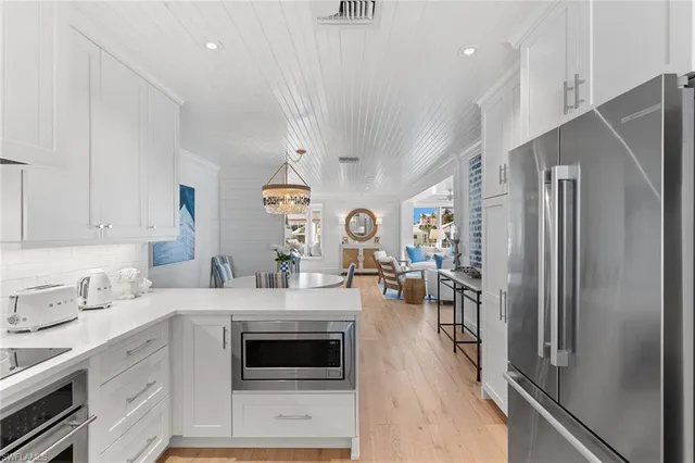 a kitchen with a refrigerator a sink dishwasher a stove and a oven with cabinets