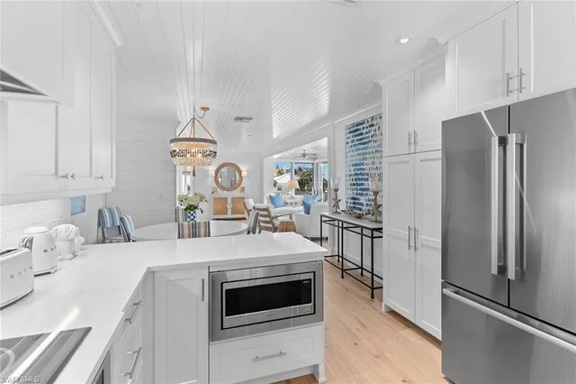 a kitchen with stainless steel appliances kitchen island granite countertop a refrigerator stove and sink