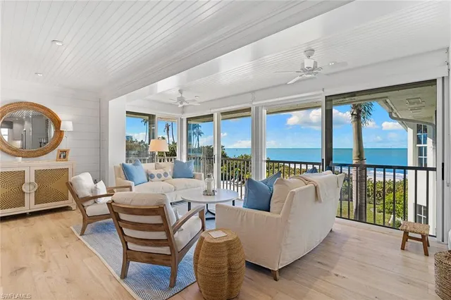 a living room with furniture a large window and a chandelier