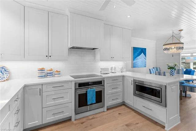 a kitchen with granite countertop white cabinets and white appliances