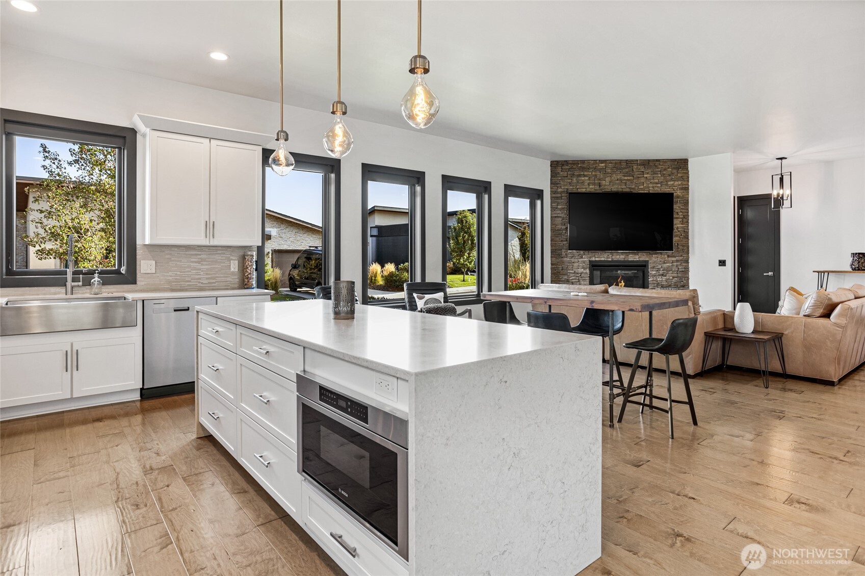 4305 Catalyss Way Yakima, WA 98908 - Photo 15 of 35 a large kitchen with stainless steel appliances a stove a sink dishwasher a dining table and chairs with wooden floor