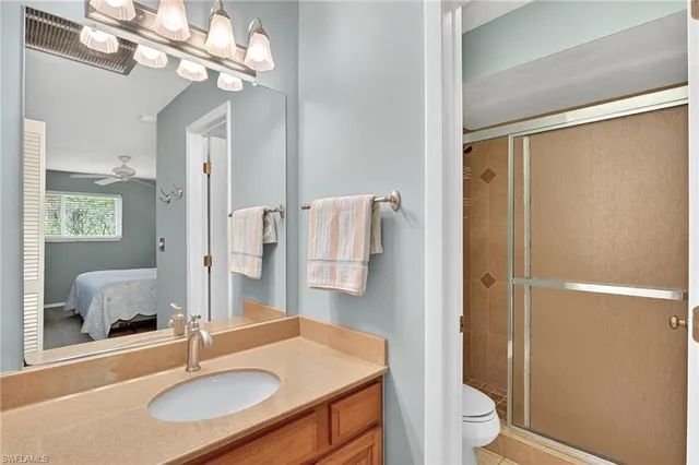 a bathroom with a sink toilet a mirror and shower