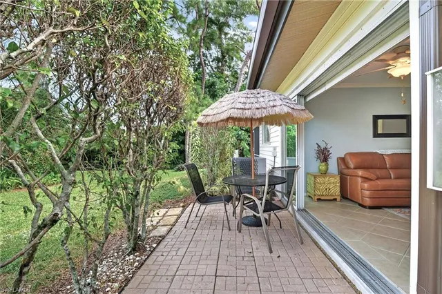 a view of a patio with table and chairs under an umbrella with wooden floor