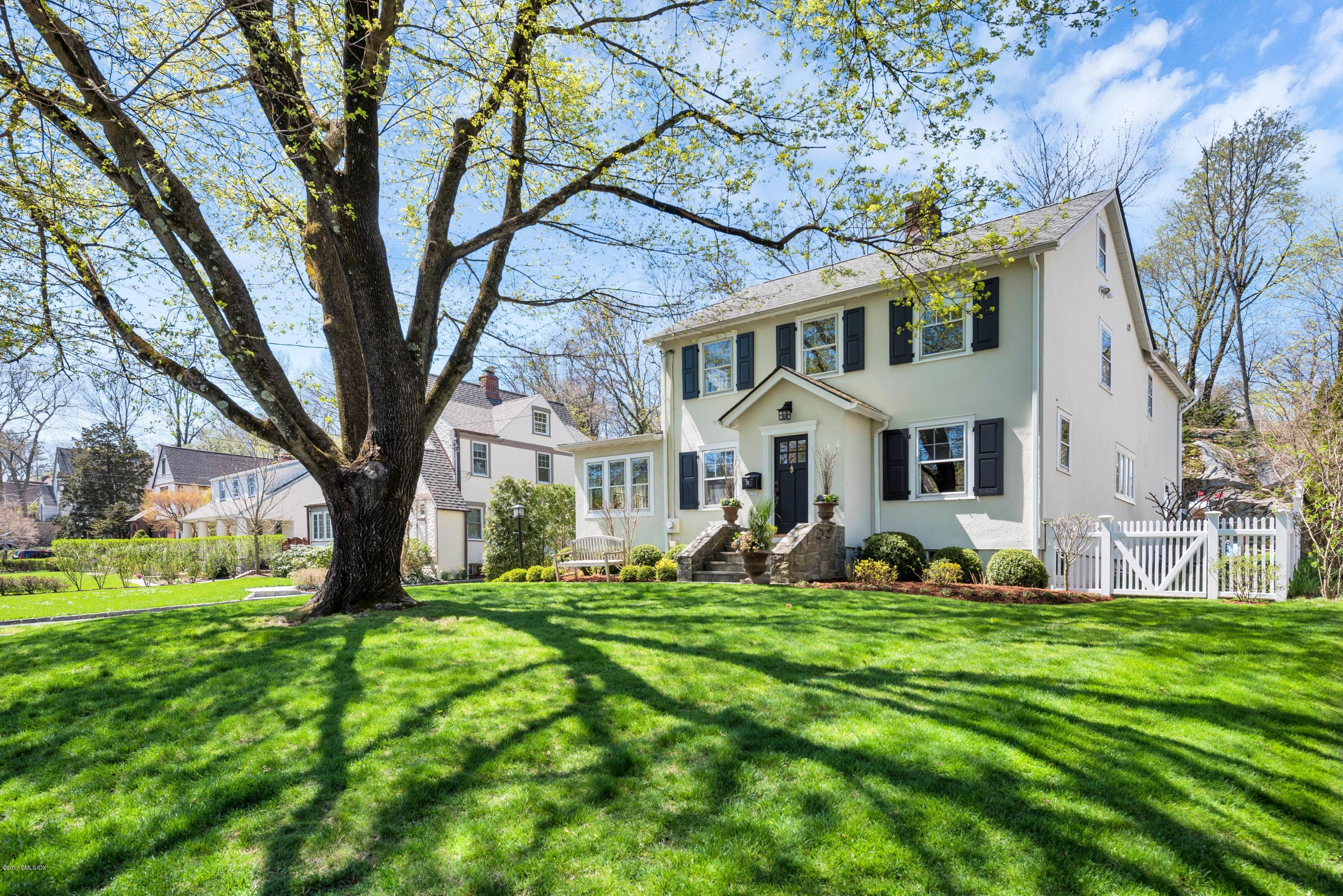 76 Valleywood Road Cos Cob, CT 06830 - Photo 3 of 24 a view of a white house with a big yard and large trees