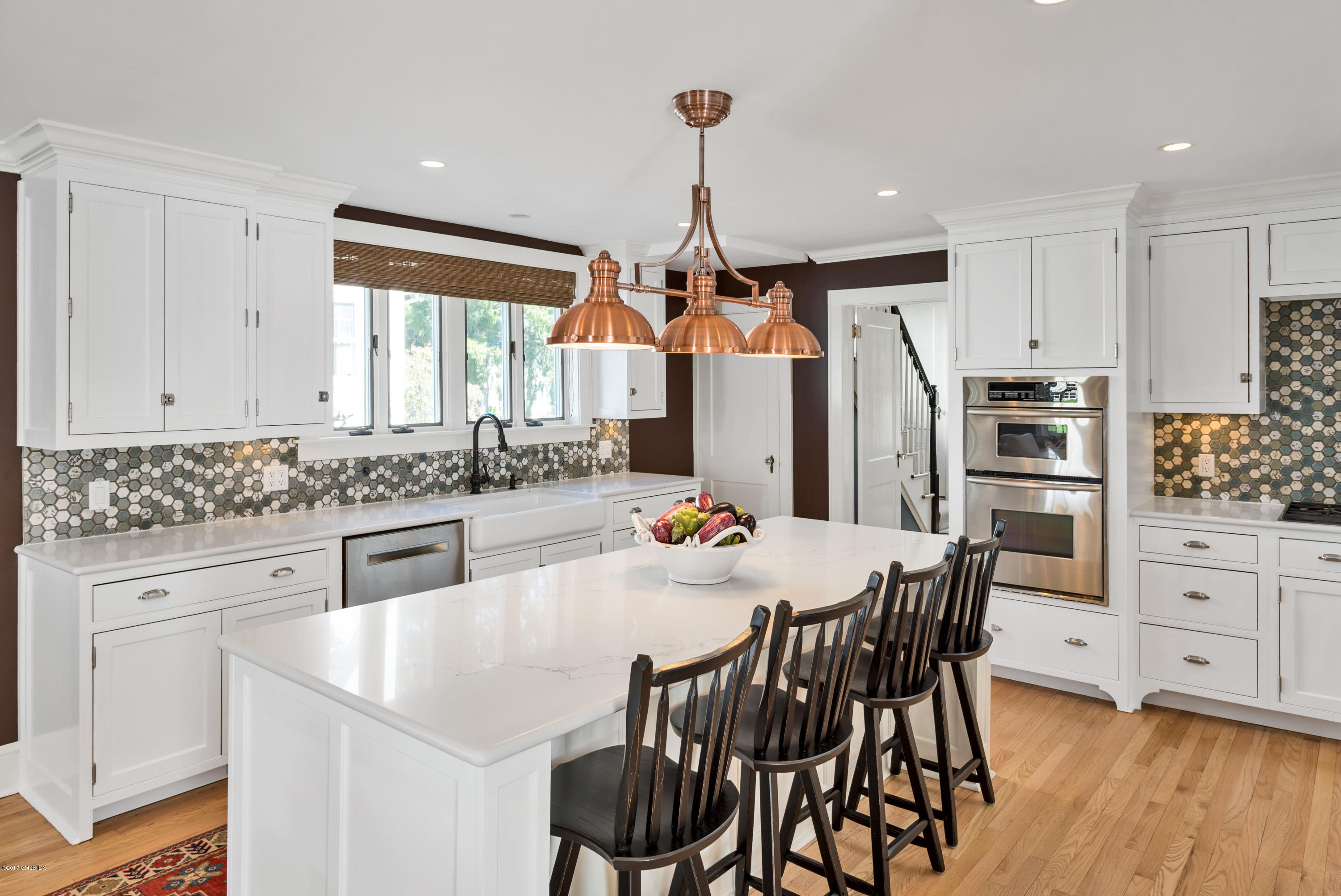 76 Valleywood Road Cos Cob, CT 06830 - Photo 9 of 24 a kitchen with stainless steel appliances kitchen island granite countertop a dining table chairs and white cabinets