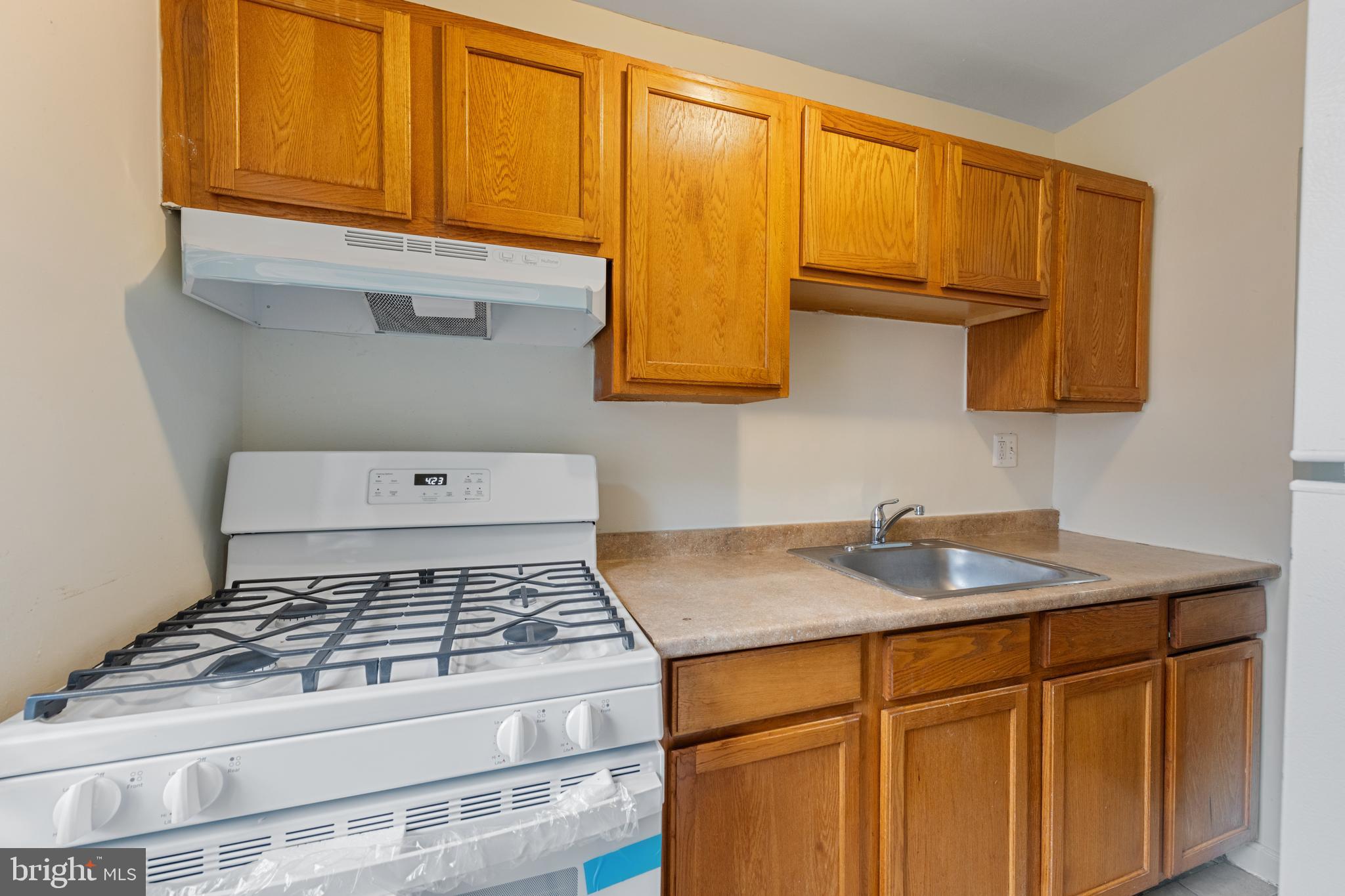 2400 Good Hope Road Southeast, Unit 103 Washington, DC 20020 - Photo 8 of 14 a kitchen with granite countertop a sink stove and cabinets