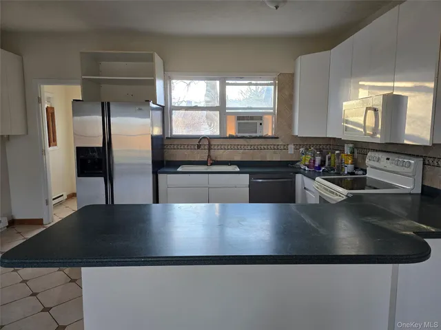 a kitchen with stainless steel appliances granite countertop a sink a stove and a refrigerator