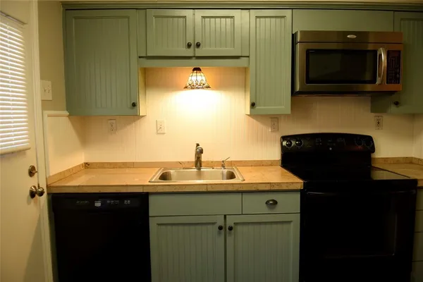 a kitchen with stainless steel appliances granite countertop a sink a stove and microwave